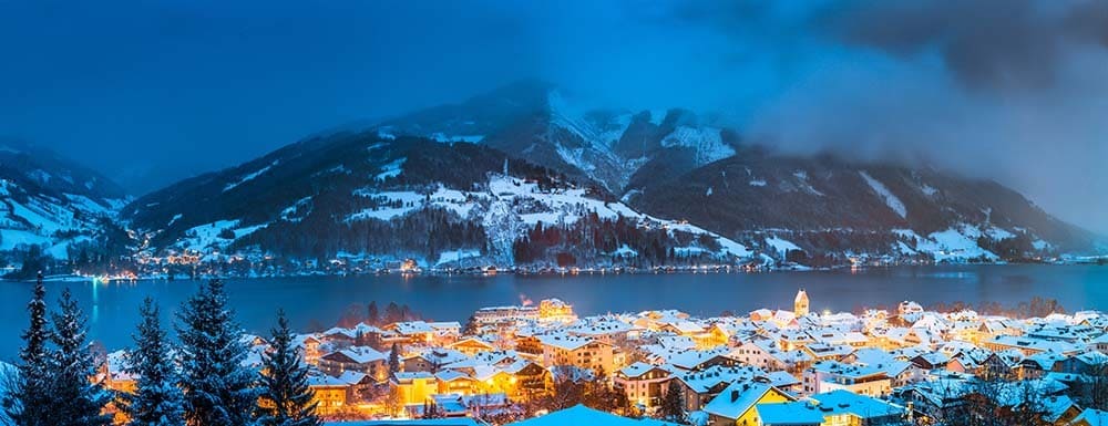 Panoramic view of Zell am See with Zeller See lake in twilight during blue hour at dusk in winter, Salzburger Land, Austria